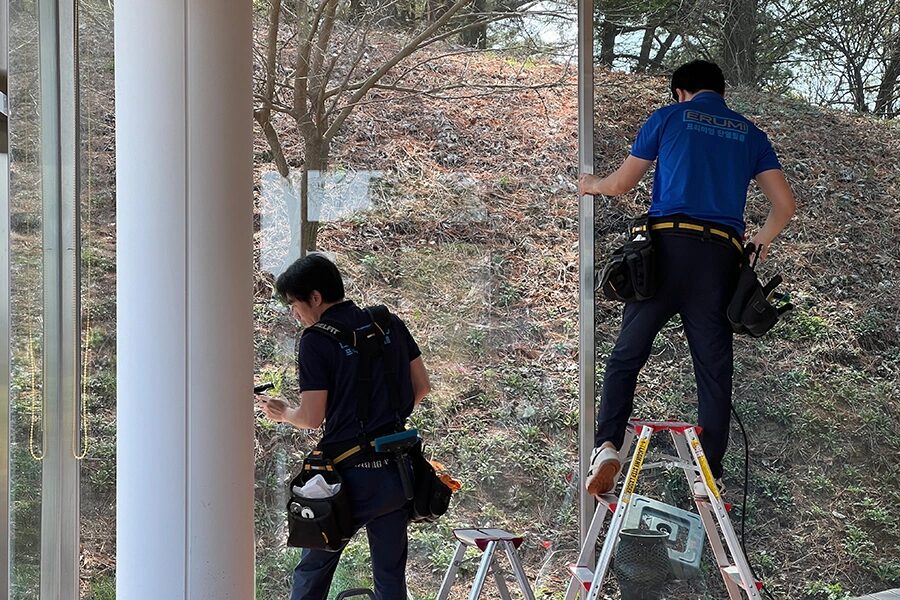 음성 골프장 그늘집 사다리를 이용해 유리 상단까지 시공하는 모습
